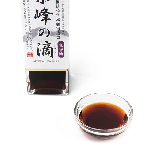 A bowl of raw soy sauce next to package bottle of the product