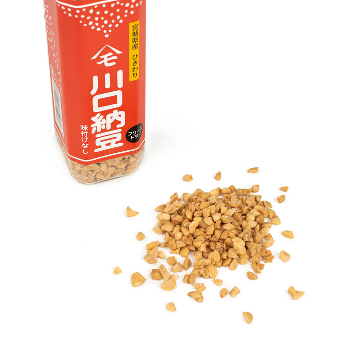 Scattered dried natto next to a package bottle of the product