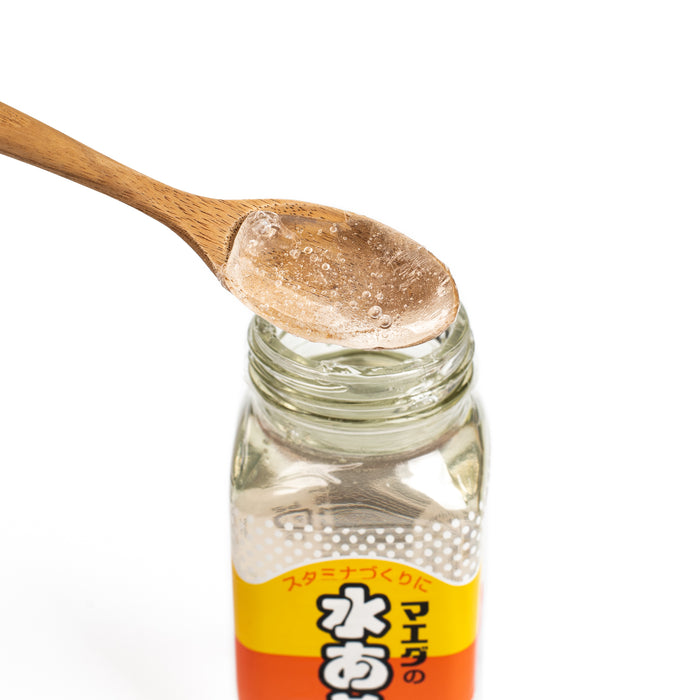 Man scooping mizuame with wooden spoon