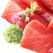 Five pieces of tuna sashimi next to coarsely grated hon wasabi