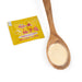 A spoon of yuzu salt next to a sachet of the product 