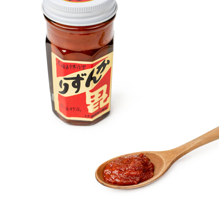 A spoon of kanzuri chili sauce next to a package jar of the product