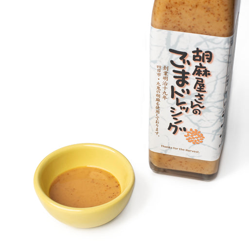 A small bowl of sesame dressing next to bottle of the product