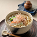 A bowl of kishimen noodles with clear dashi soup topped with bonito flakes