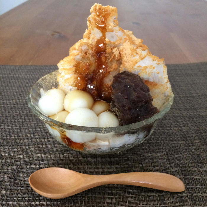 A bowl of shaved ice topped with kinako powder and tsubuan