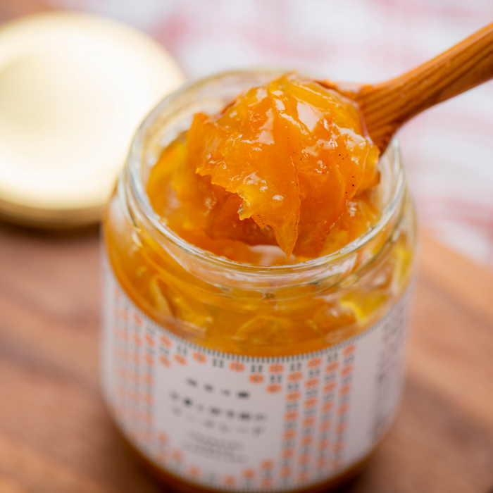 Scooping marmalade with wooden spoon