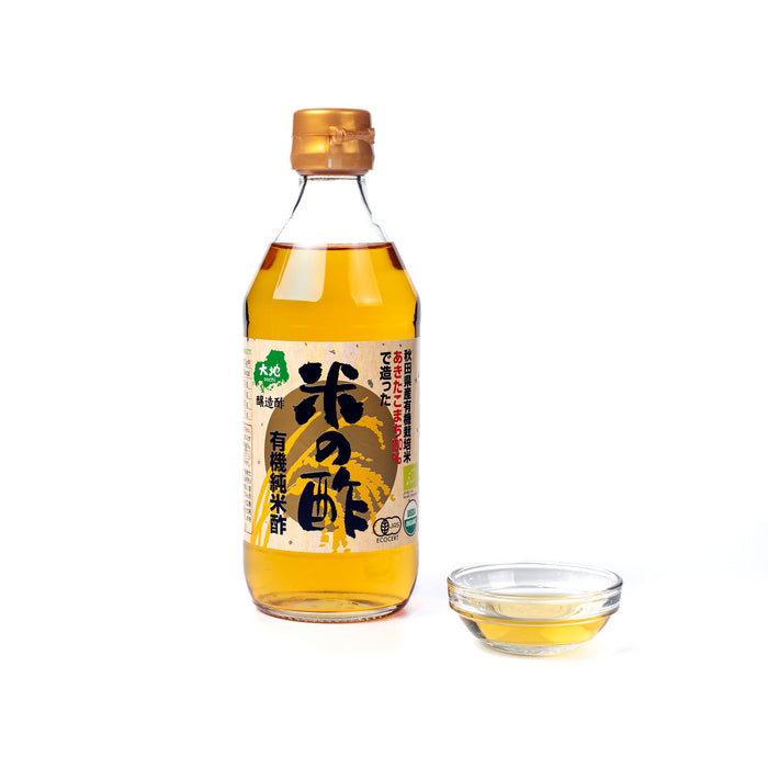 A bottle of the product next to a small bowl of organic rice vinegar
