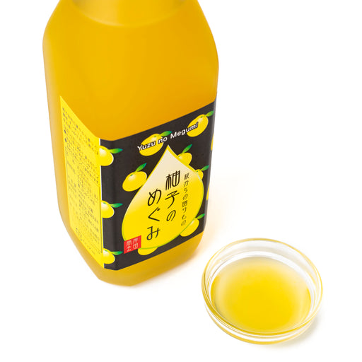A glass bowl of yuzu syrup next to bottle of the product