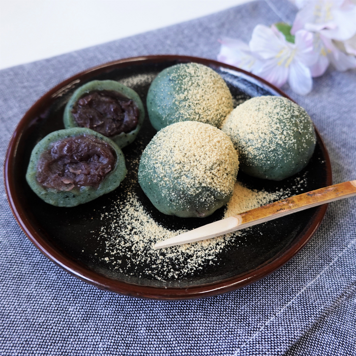 A plate of four daifuku mochi topped with kinako powder