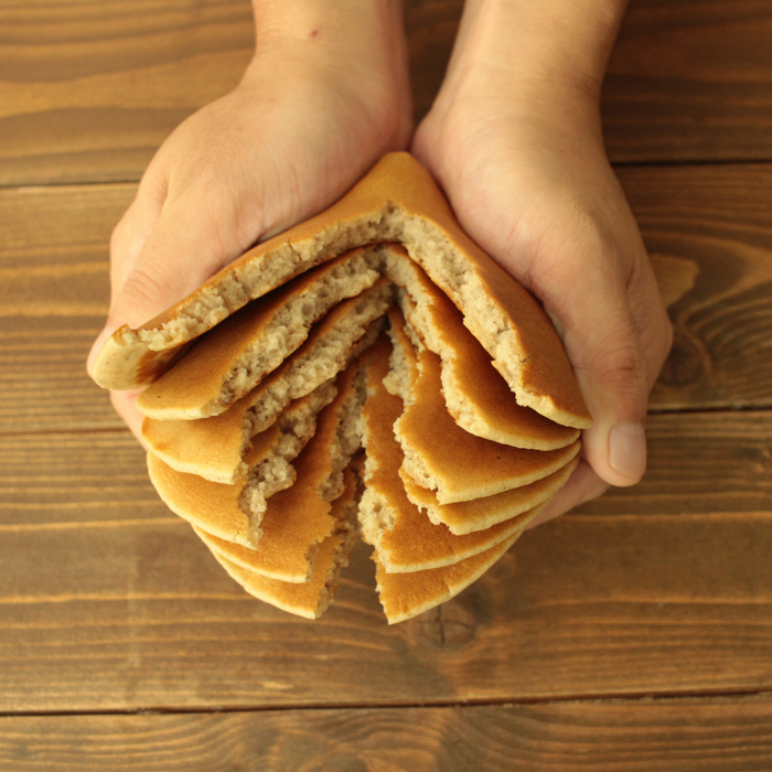 Man holding rice flour pancakes with both hands