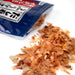 Scattered dried bonito flakes popping out of package of the product