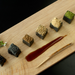A plate of black sesame tofu topped with a variety of garnishes