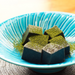 A plate of black sesame tofu topped with matcha powder