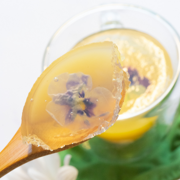 A spoon of jelly topped with edible flowers