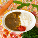 A plate of curry with rice with vegetable pickles