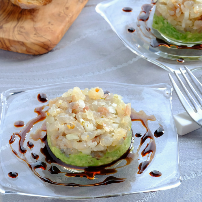 A plate of avocado tartar topped with minced seafood