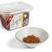 A small bowl of two year fermented miso next to package of the product