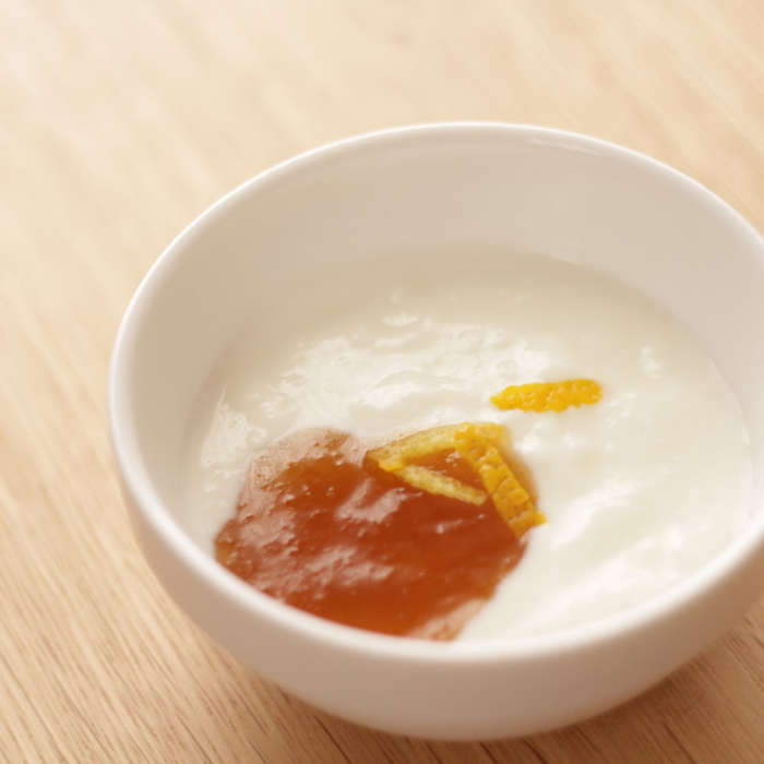 A bowl of yogurt topped with yuzu peel and organic yuzu spread