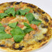 A whole pie of pizza topped with nori seaweed paste and basil
