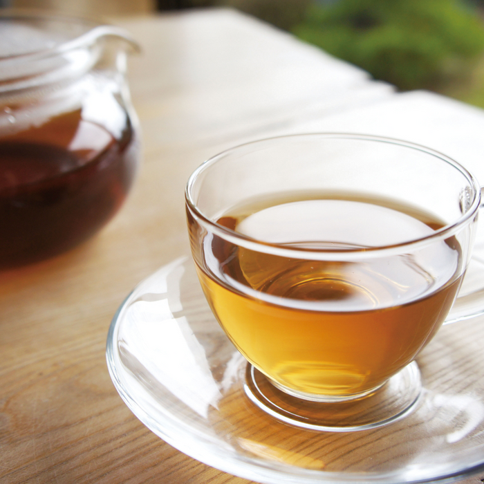 A cup of shiso tea next to a pot