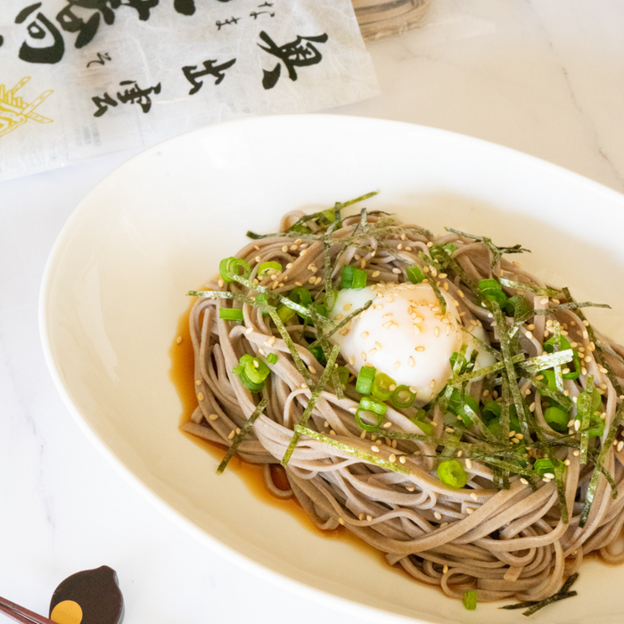 A bowl of cold soba noodles topped with boiled egg