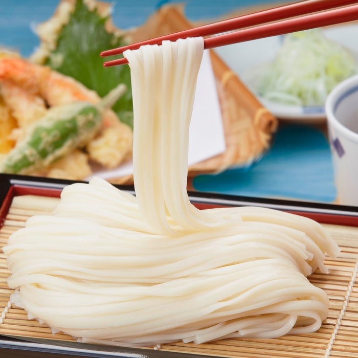 Man taking cold udon noodles with chopsticks