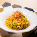 A plate of pasta dishes topped with dried bonito flakes