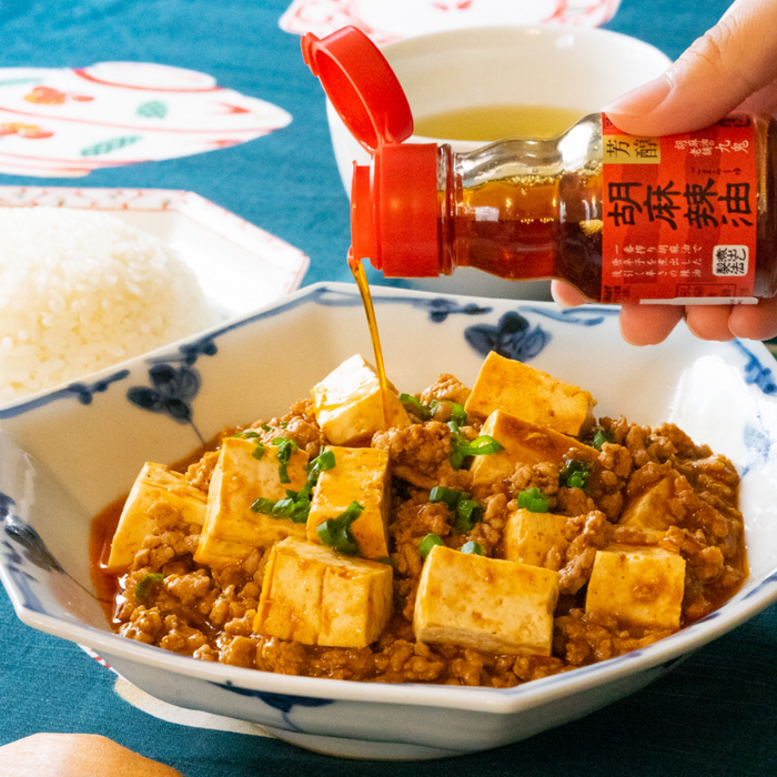 Mapo tofu being drizzled with rayu from bottle of the product