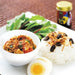 A bowl of stir-fried ground pork topped with shichimi togarashi pepper powder next to steamed rice and boiled egg