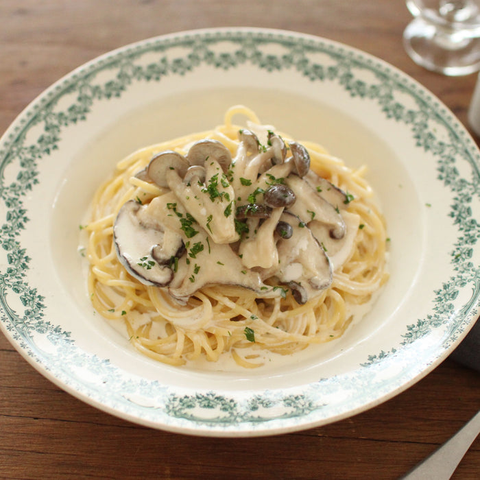 A plate of creamy sauce spaghetti topped with mushrooms and truffle infused soy sauce