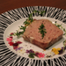 A plate of meatloaf decorated with dried edible flowers