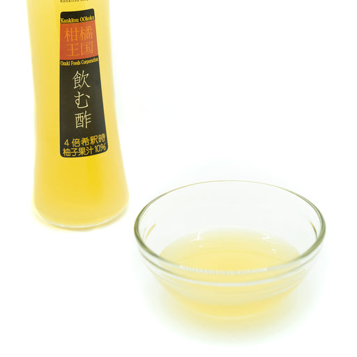 A bowl of Drinking Vinegar Mixer - Yuzu next to a bottle of the product